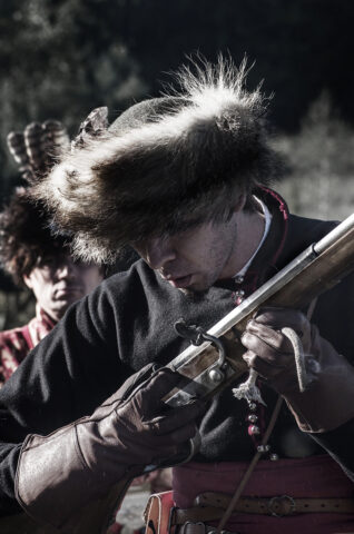 Szlachcic trzymający czarnoprochowca w ręku podczas pokazu historycznego.